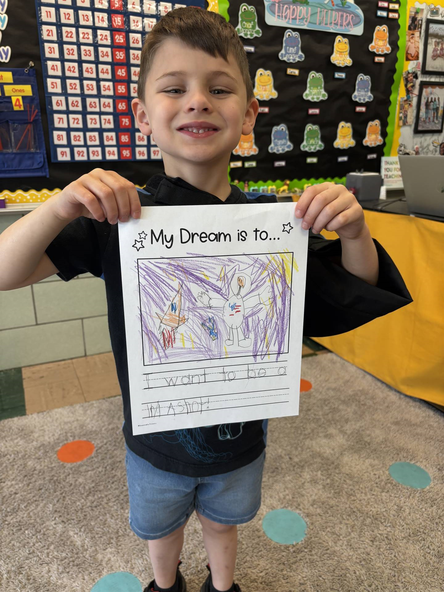 Student holding up his work with his career dream.